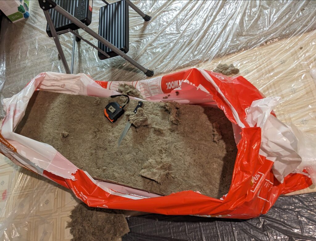Working with Rockwool- dedicated knife (since upgraded to a bread knife) and the all-important plastic sheeting down