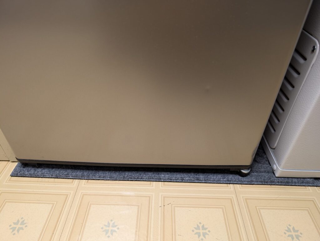 Rug beneath the mini-fridge and freezer
